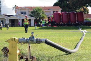 JAMM AQUINO / JAQUINO@STARADVERTISER.COM
                                The Navy began flushing water lines at Pearl City Peninsula military housing last week. Above, a hydrant pumped ground water into four large filtration tanks at the complex. At left, clean water that passed through filtration was emptied onto a field.