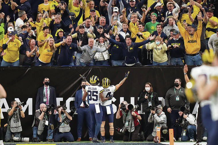ASSOCIATED PRESS
                                Michigan wide receiver Roman Wilson (14), a Saint Louis alum, celebrated with teammate Daylen Baldwin after catching a 75-yard touchdown pass against Iowa in Saturday’s Big Ten championship game in Indianapolis. Wilson’s Wolverines will participate in the College Football Playoff semifinals.