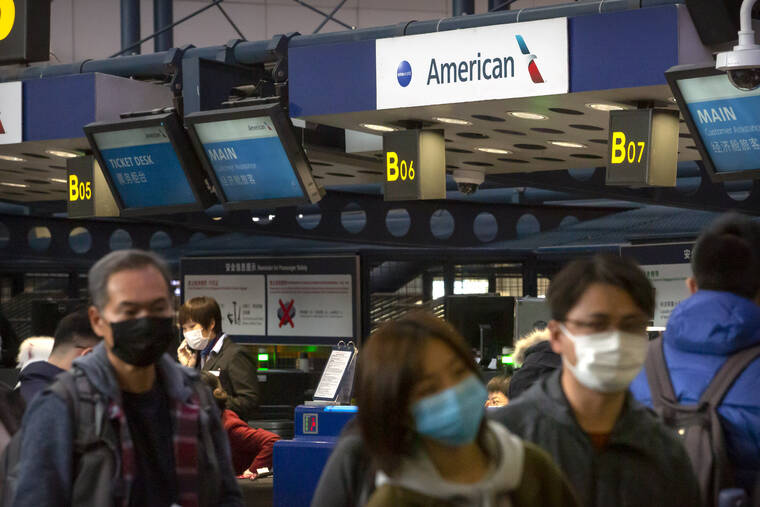 ASSOCIATED PRESS / 2020
                                Travelers wearing face masks line up to check in for an American Airlines flight to Los Angeles at Beijing Capital International Airport in Beijing.