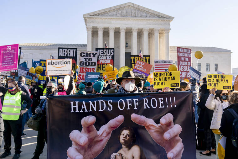 ASSOCIATED PRESS
                                Stephen Parlato of Boulder, Colo., holds a sign that reads “Hands Off Roe!!!” as abortion rights advocates and anti-abortion protesters demonstrate in front of the U.S. Supreme Court on Dec. 1 in Washington.