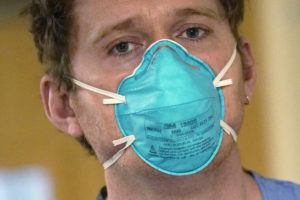 ELAINE THOMPSON / AP
                                Registered nurse Scott McGieson wears an N95 mask as he walks out of a patient’s room in the acute care unit of Harborview Medical Center, Friday, Jan. 14, in Seattle.