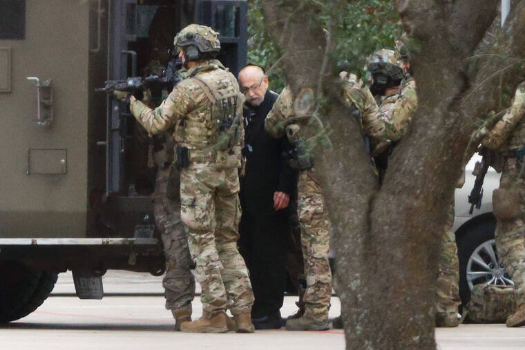 ELIAS VALVERDE/THE DALLAS MORNING NEWS VIA ASSOCIATED PRESS
                                Shortly after 5 p.m., local time, authorities escorted a hostage out of the Congregation Beth Israel synagogue in Colleyville, Texas, Saturday. Police said the man was not hurt and would be reunited with his family.