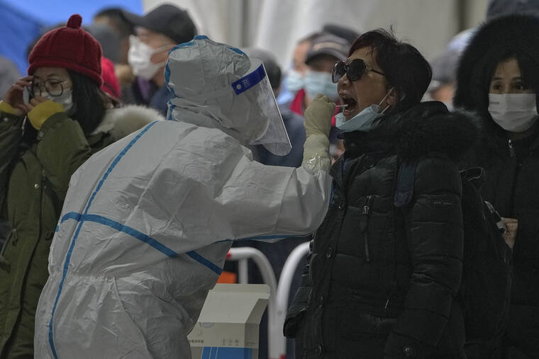 ASSOCIATED PRESS|
                                A woman got a throat swab at a mass coronavirus testing site in Beijing, Monday. Chinese authorities lifted a monthlong lockdown of Xi’an and its 13 million residents as infections subside ahead of the Winter Olympics. Meanwhile, the 2 million residents of one Beijing district are being tested following a series of cases in the capital.