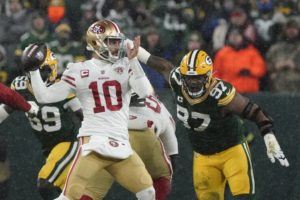ASSOCIATED PRESS
                                San Francisco’s Jimmy Garoppolo throws with Green Bay’s Kenny Clark defending on Saturday.