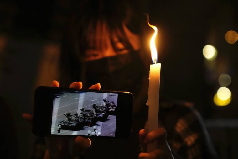 ASSOCIATED PRESS
                                A woman holds up a lit candle and a phone showing the image of the 1989 tank man protester during a candle vigil to mark the anniversary of the military crackdown on a pro-democracy student movement in Beijing outside Victoria Park in Hong Kong on June 4.