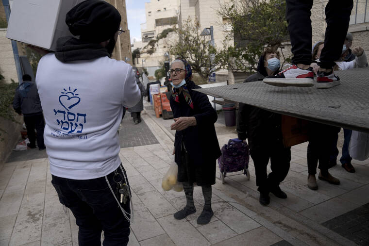 ASSOCIATED PRESS
                                A volunteer assists as several dozen impoverished elderly Israelis, many of them Holocaust survivors, gather for distribution of food aid and cold weather supplies by the Chasdei Naomi charity in Jerusalem.