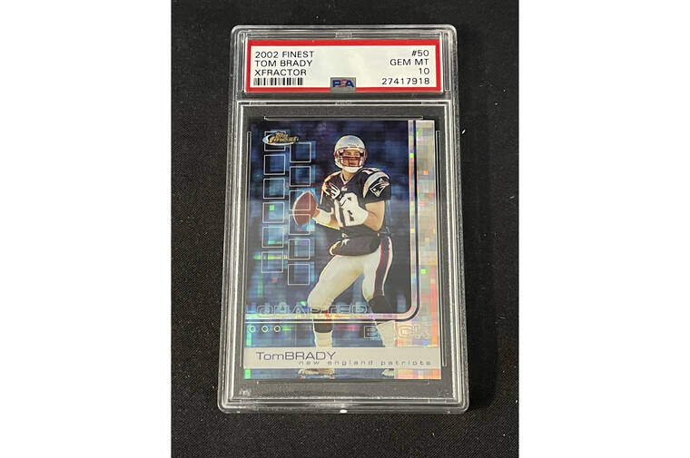 ASSOCIATED PRESS
                                In this photo provided by Saco River Auction LLC, a 2002 Topps Finest X-Fractor card showing football quarterback Tom Brady rests inside a transparent case, Wednesday, Jan. 19, 2022, in Gorham, Maine. Troy Thibodeau from Saco River Auction estimates the card will fetch six figures when it’s auctioned on Jan. 31.