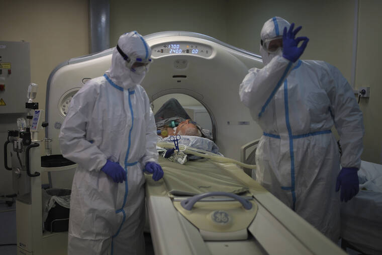ASSOCIATED PRESS / JAN. 27
                                Medical staff members transfer a patient with COVID-19 into a Magnetic resonance imaging system at an ICU of an hospital in Krasnodar, southern Russia.