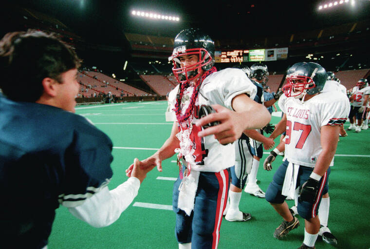 GEORGE F. LEE / 1999
                                Saint Louis quarterback Timmy Chang was congratulated by Kamehameha’s Ikaika DuPont after a game at Aloha Stadium on Nov. 11, 1999.