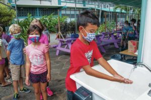 CRAIG T. KOJIMA / 2021
                                Students lined up to wash their hands after returning from the playground at Kaohao Charter School in Lanikai last year.