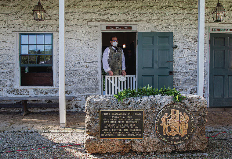 CINDY ELLEN RUSSELL / CRUSSELL@STARADVERTISER.COM
                                A plaque in front of Ka Hale Pa‘i, where the replica printing press resides, depicts the Jan. 7, 1922, event in which Keeaumoku, governor of Maui, created the first sheet of the Hawaiian Primer. Pictured standing in the doorway is Mike Smola, curator of public programs.