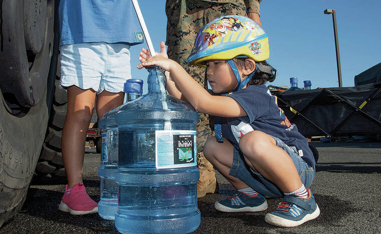 CRAIG T. KOJIMA /CKOJIMA@STARADVERTISER.COM
                                Yuno Chan filled a water bottle with help from his sister Yua.