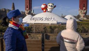 MARK SCHIEFELBEIN / AP
                                People wearing face masks to protect against coronavirus look at a display of the Winter Paralympic mascot Shuey Rhon Rhon, left, and Winter Olympic mascot Bing Dwen Dwen near the Olympic Green in Beijing.