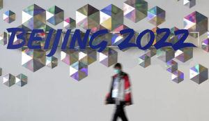 DAVID J. PHILLIP / AP
                                A person walks past a Beijing 2022 sign inside the main media center at the 2022 Winter Olympics.