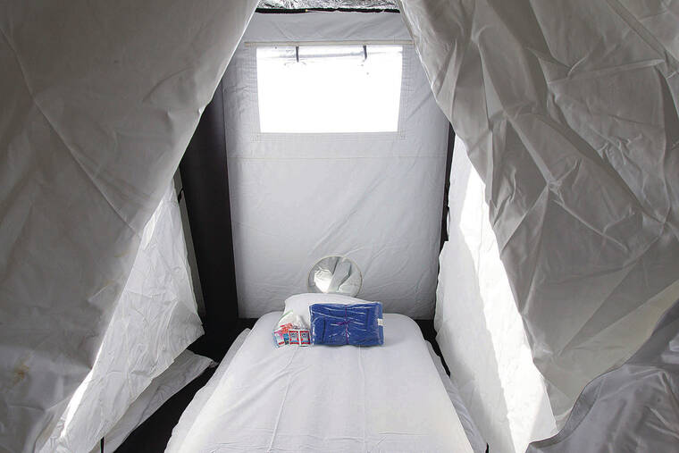 CINDY ELLEN RUSSELL / CRUSSELL@STARADVERTISER.COM
                                A view of a room, which consists of a bed with a welcome package of a blanket and toiletries.