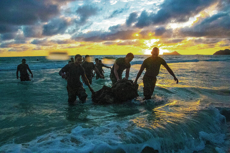 CRAIG T. KOJIMA / CKOJIMA@STARADVERTISER.COM
                                University of Hawaii Army ROTC members swam in uniform through surf at Bellows Field Beach Park lugging a raft of rucksacks.