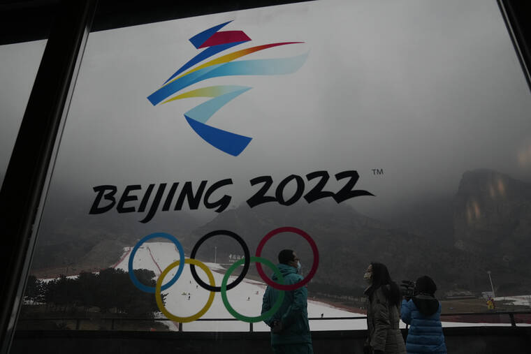 ASSOCIATED PRESS
                                Visitors stand near a logo for the 2022 Beijing Winter Olympics at a ski resort in Yanqing on the outskirts of Beijing on Dec. 23.