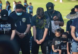 CINDY ELLEN RUSSELL / CRUSSELL@STARADVERTISER.COM
                                Supporters gathered Wednesday in memory of police officers Tiffany Enriquez and Kaulike Kalama, who were fatally shot on Hibiscus Drive two years ago. Pictured wearing lei and with his head bowed in prayer is Kalama’s son, Kaumana.