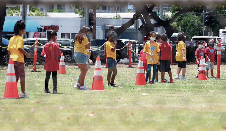 JAMM AQUINO / AUG. 13
                                Isle students returned to classrooms today at 257 public schools across the state. Above, children wearing masks line up in socially distanced order after outdoor activity at Queen Kaahumanu Elementary School.