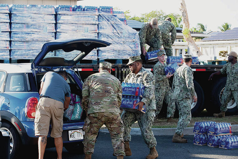 GEORGE F. LEE / DEC. 1
                                About 93,000 people in neighborhoods in and around Joint Base Pearl Harbor- Hickam have been affected by the water contamination. Above, Navy personnel distribute water to families at the Halsey Terrace Community Center.