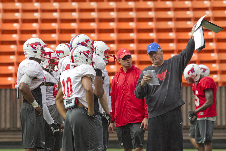 CINDY ELLEN RUSSELL / 2012
                                SMU head coach June Jones, right, and graduate assistant Timmy Chang talk to players during practice in 2012 at Aloha Stadium.