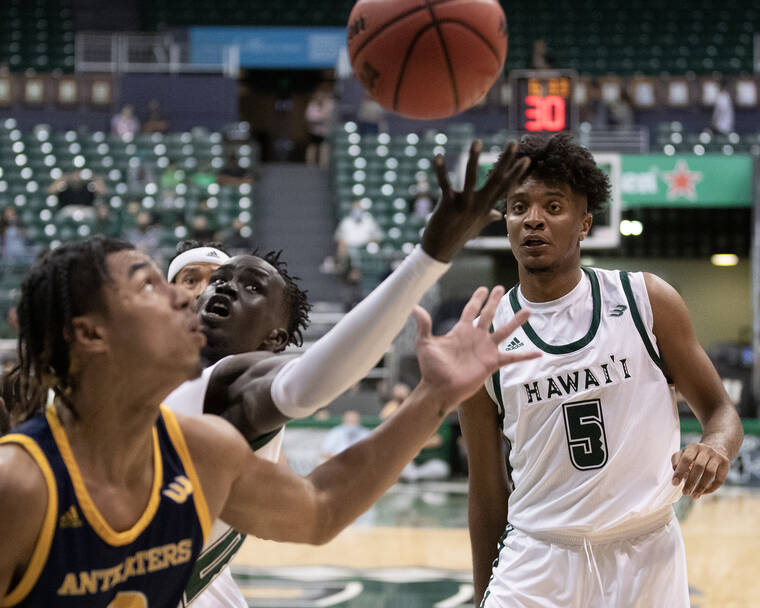 GEORGE F. LEE / GLEE@STARADVERTISER.COM
                                Hawaii’s Junior Madut reached out for a loose ball against UC Irvine’s JC Butler on Thursday.