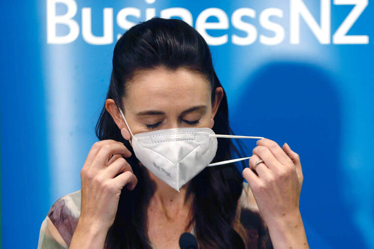 NEW ZEALAND HERALD / AP
                                New Zealand Prime Minister Jacinda Ardern removes her mask before she outlines the Government’s plans that will dismantle its quarantine system and reopen its borders the world.