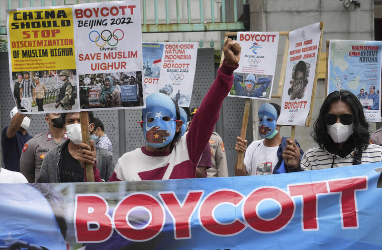 ASSOCIATED PRESS
                                Student activists, some wearing masks with the colors of the pro-independence East Turkistan flag, shout slogans during a rally to protest the Beijing 2022 Winter Olympic Games outside the Chinese Embassy in Jakarta, Indonesia on Jan. 14.