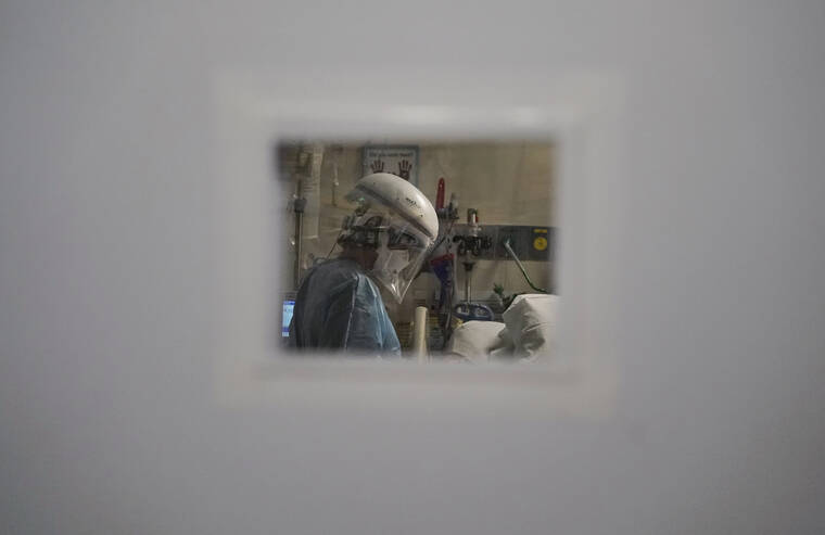ASSOCIATED PRESS
                                A nurse tending to a COVID-19 patient is seen through a small window in an intensive care unit at Mission Hospital in Mission Viejo, Calif., in 2020.