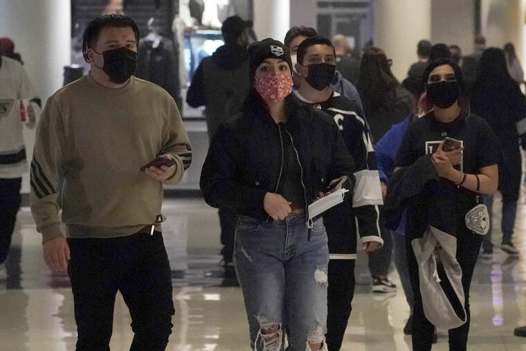 ASSOCIATED PRESS
                                Fans wear masks as they walk inside crypto.com Arena before an NHL hockey game between the Los Angeles Kings and the Nashville Predators on Jan. 6 in Los Angeles. California will end its indoor masking requirement next week as the latest surge eases with the more infectious omicron variant passing its peak, the state health office said.