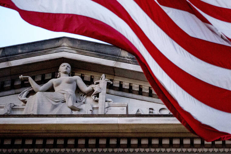 ASSOCIATED PRESS
                                An American flag flew outside the Department of Justice in Washington, in March 2019. The Justice Department said a New York couple was arrested today on charges of conspiring to launder cryptocurrency that was stolen from a 2016 hack of a virtual currency exchange.