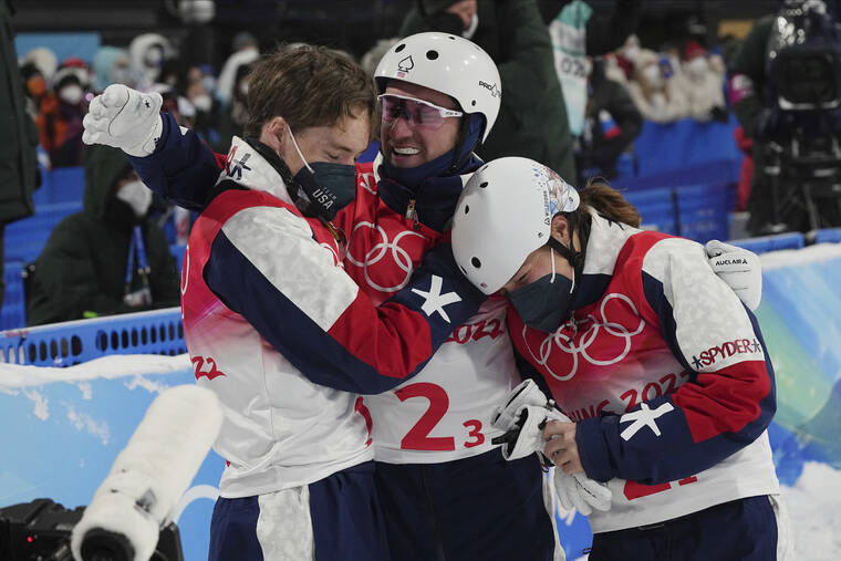 ASSOCIATED PRESS United States’ Justin Schoenefeld, center, celebrates with Christopher Lillis, left, and Ashley Caldwell during the mixed team aerials finals at the 2022 Winter Olympics in Zhangjiakou, China.