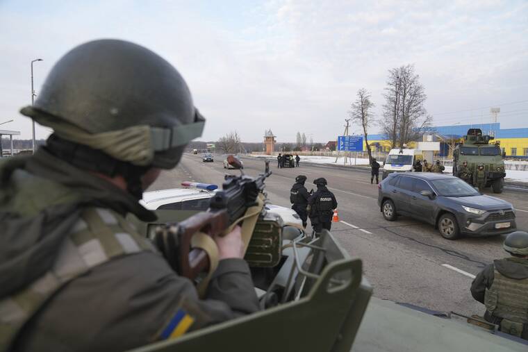 ASSOCIATED PRESS
                                A Ukrainian National guard soldier, left, holds his weapon ready as he guards the mobile checkpoint with the Ukrainian Security Service agents and police officers in Kharkiv, Ukraine, today.