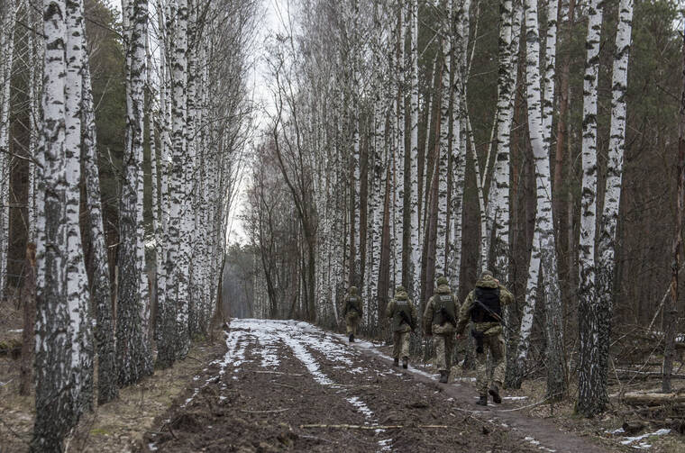 ASSOCIATED PRESS
                                Ukrainian border guard officers patrol the Ukrainian-Belarusian state border at a checkpoint in Novi Yarylovychi, Ukraine, today.