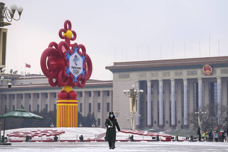 ASSOCIATED PRESS
                                A paramilitary police officer wearing a face mask marches past a decoration for the Beijing Winter Olympics Games in front of the Great Hall of the People on Tiananmen Square in Beijing on Jan. 20.