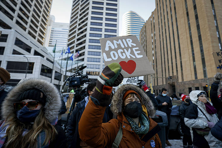 A protester holds a sign with Amir Locke's name on it at a rally on Saturday, Feb. 5, 2022, in Minneapolis. Hundreds of people filled the streets of downtown Minneapolis after body cam footage released by the Minneapolis Police Department showed an officer shoot and kill Locke during a no-knock warrant. (AP Photo/Christian Monterrosa)
