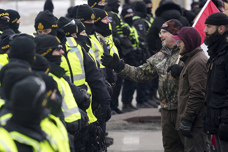 THE CANADIAN PRESS / AP
                                A protester attempts to speak with police officers as they enforce an injunction against their demonstration, which has blocked traffic across the Ambassador Bridge by protesters against COVID-19 restrictions, in Windsor, Ont.