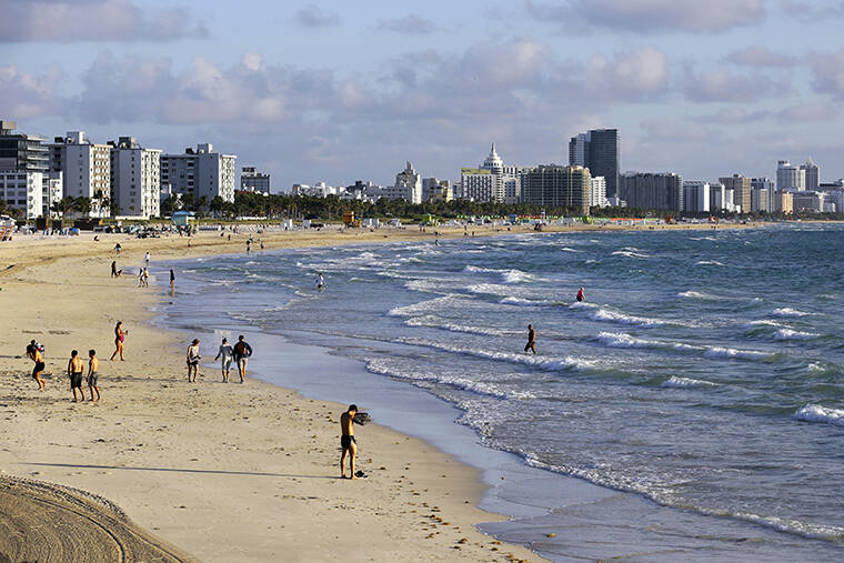 ASSOCIATED PRESS / 2020
                                Beachgoers walk along South Beach in Miami Beach, Fla.