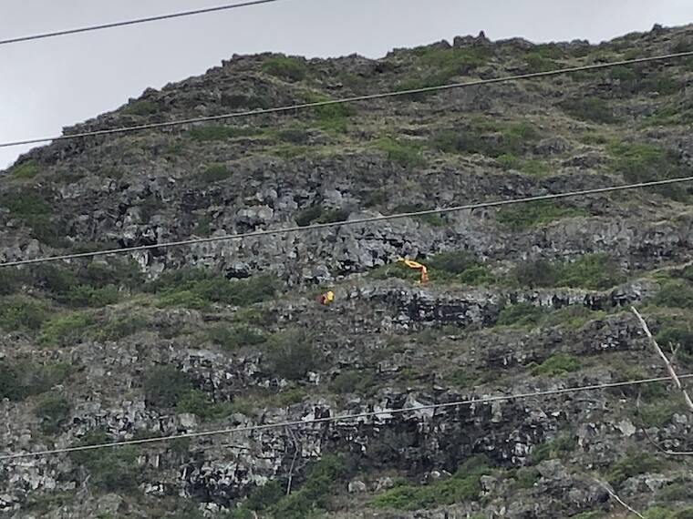 LEILA FUJIMORI / LFUJIMORI@STARADVERTISER.COM
                                A parachute is seen left on the side of the mountain near the Makai Research Pier in Waimanalo after Honolulu Fire Department officials rescued an injured paraglider this afternoon.
