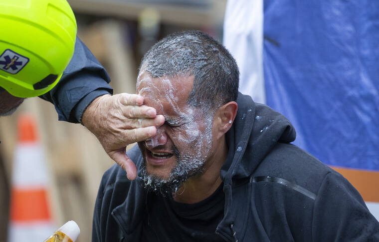 NEW ZEALAND HERALD / AP
                                A demonstrator receives medial attention after he was sprayed by police at a protest opposing coronavirus vaccine mandates in Wellington, New Zealand.