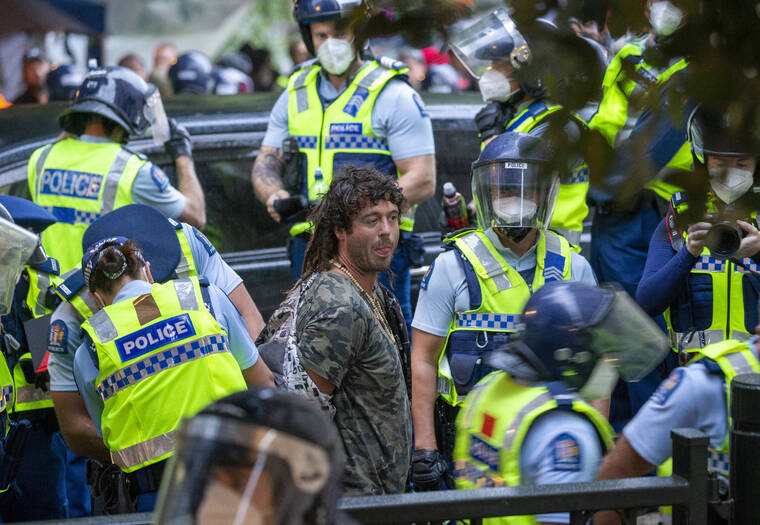 NEW ZEALAND HERALD / AP
                                A demonstrator is arrested at a protest opposing coronavirus vaccine mandates in Wellington, New Zealand.
