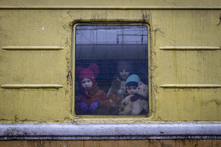 ASSOCIATED PRESS
                                Children Vlada, left, Katrin and Danilo looked out from a window of an unheated train carriage of an emergency evacuation train which was traveling from Kharkov to Lviv, as it stopped in the Kyiv railway station in Kyiv, Ukraine, today.