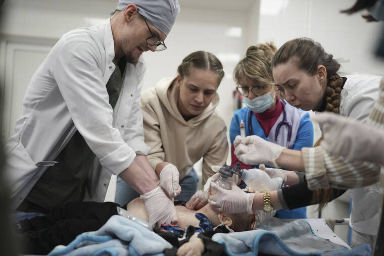 ASSOCIATED PRESS / MARCH 4
                                Medical workers try to save the life of Marina Yatsko’s 18 month-old son Kirill, who was fatally wounded by shelling, at a hospital in Mariupol, Ukraine.
