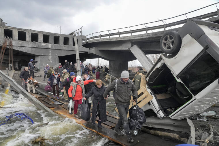 ASSOCIATED PRESS
                                People crossed an improvised path under a destroyed bridge while fleeing the town of Irpin close to Kyiv, Ukraine, today. Russia announced yet another cease-fire and a handful of humanitarian corridors to allow civilians to flee Ukraine.