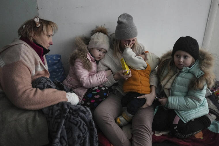 ASSOCIATED PRESS
                                Women and children sit on the floor of a corridor in a hospital in Mariupol, eastern Ukraine, on Friday.