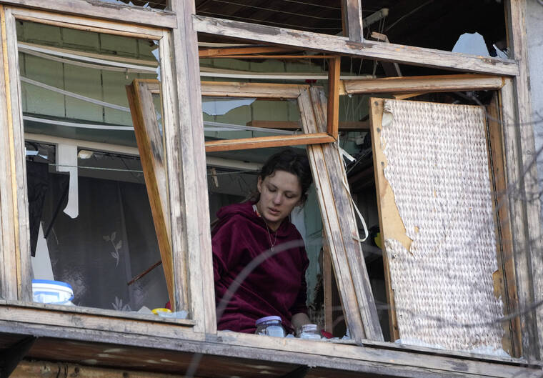 ASSOCIATED PRESS
                                A woman stood near a broken window in her apartment after a Russian bombing attack in Kyiv, Ukraine, today.