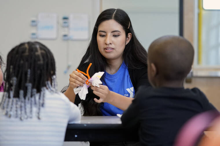 ASSOCIATED PRESS / MARCH 16
                                Lesly Mendez works with children in a before- and afterschool program operated by the YMCA of Middle Tennessee in Nashville, Tenn.