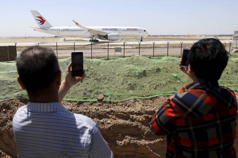 ASSOCIATED PRESS
                                Residents watched as a China Eastern passenger jet prepared to take off on a test flight from the new Beijing Daxing International Airport, in May 2019. State media reported a Chinese airliner from China Eastern with 133 people on board crashed in the southern province of Guangxi on Monday, sparking a mountainside fire.