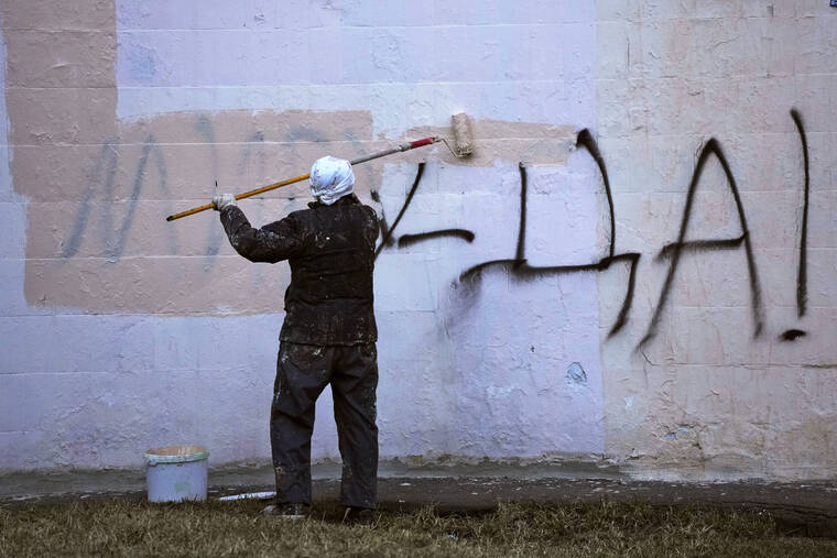 ASSOCIATED PRESS
                                A worker paints over graffiti saying ‘Yes to Peace!’ on a wall of an apartment building in St. Petersburg, Russia, on Friday.