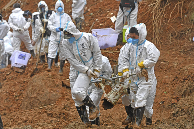 XINHUA / AP
                                Rescuers carry a piece of plane wreckage at the site of Monday’s plane crash in Tengxian County, southern China’s Guangxi Zhuang Autonomous Region, Friday, March 25. Construction excavators dug into the crash site Saturday in the search for wreckage, remains and the second black box from a China Eastern 737-800 that nosedived into a mountainside in southern China this week with 132 people on board.